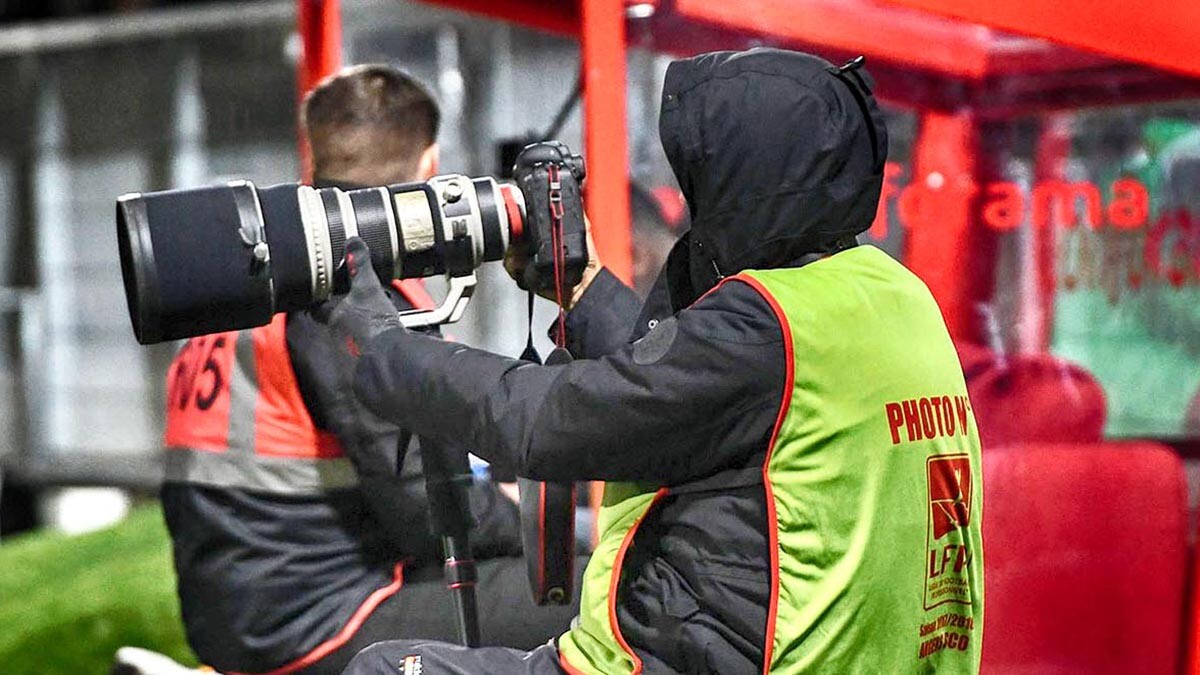 Un photographe de l'agence Ouest Médias avec un objectif Canon 400 mm durant un match de Ligue 1