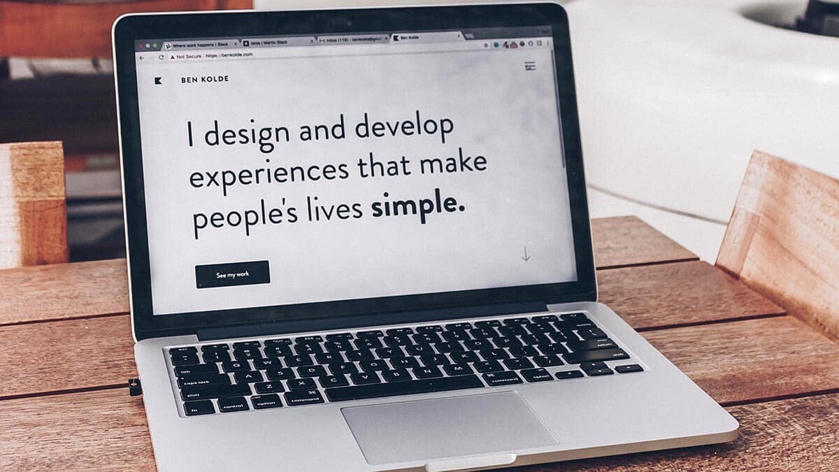 Photo d'un MacBook sur l'écran duquel il est écrit : I design and develop experiences that make people's lives simple.
