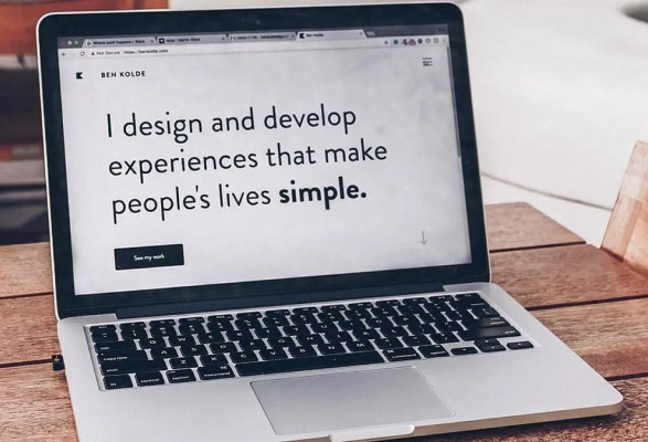 Photo d'un MacBook sur l'écran duquel il est écrit : I design and develop experiences that make people's lives simple.