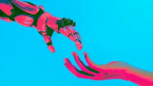 Sur fond bleu clair, une main de robot en haut à gauche qui essaye d'attraper une main humaine en bas à droite. Les 2 mains de couleur rouge un peu saturée.